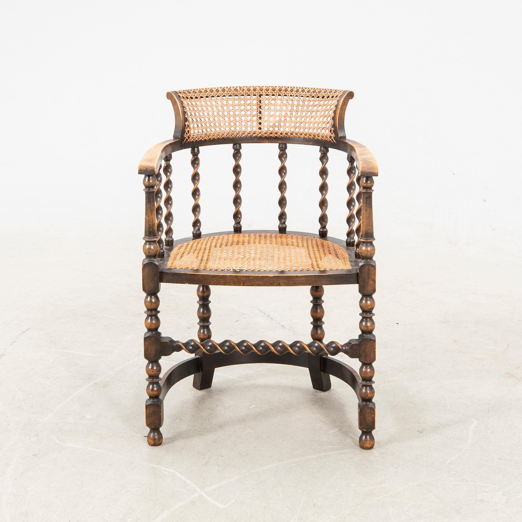A rattan and wooden barocque-style chair from the first half of the 20th century.