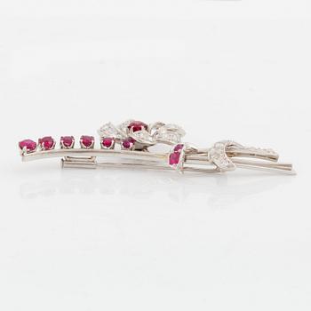 A flower brooch in platinum set with faceted rubies and round brilliant- and eight-cut diamonds.