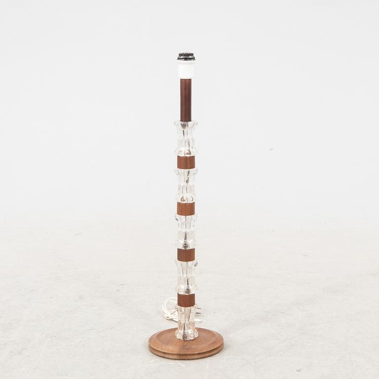 A 1970s wood and glass floor lamp.