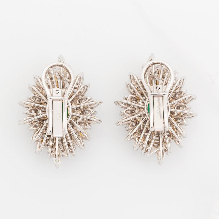 A pair of 18K white gold earrings set with faceted emeralds.