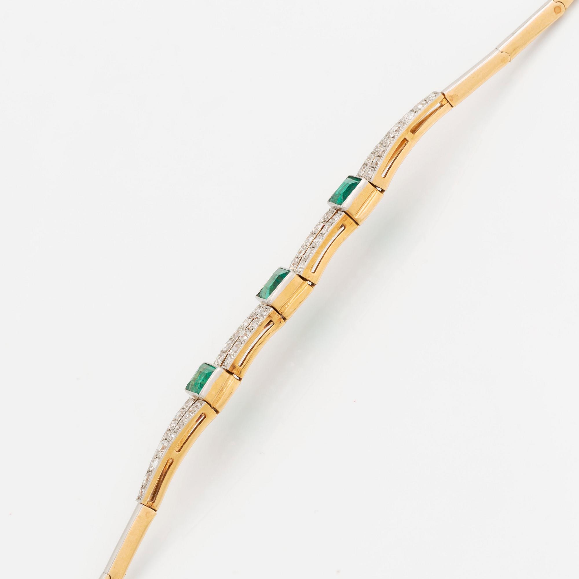 An 18K gold and platinum bracelet set with step-cut emeralds and old- and eight-cut diamonds.
