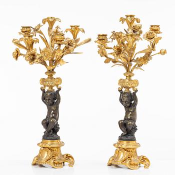 A Rococo style mantle clock and pair of candelabra, France, late 19th Century.