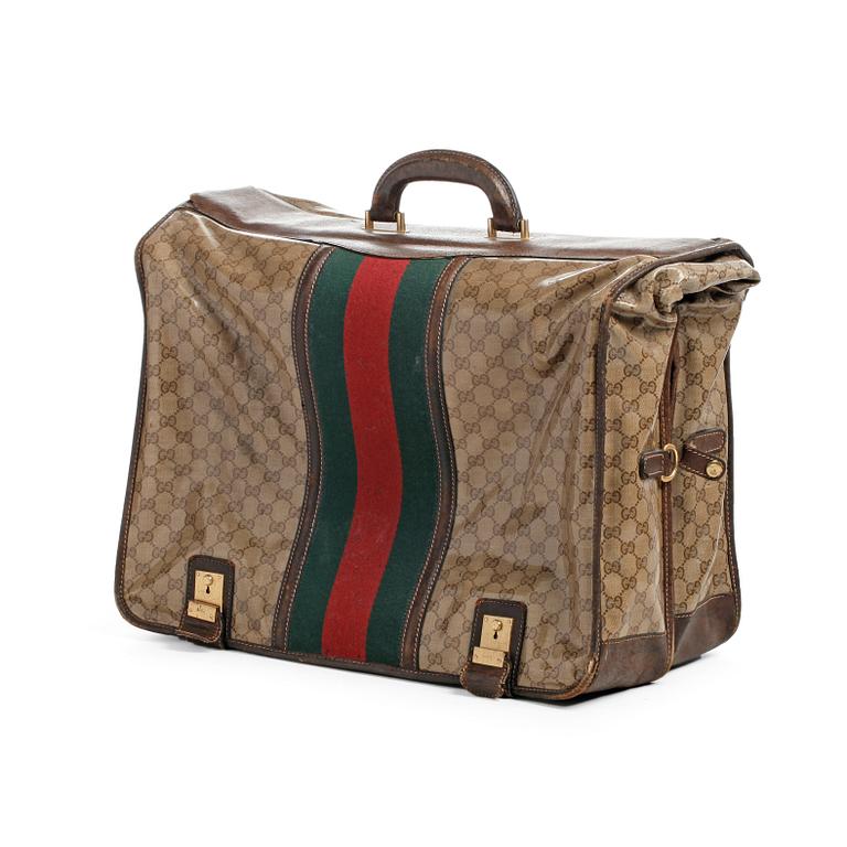 GUCCI, a monogramed waxed canvas garement cover bag.