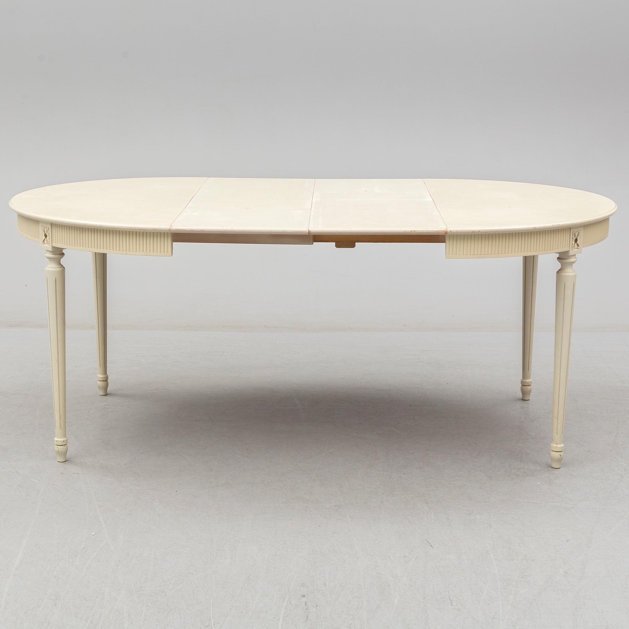 A set of eight chairs and a dining table. Gustavian style, second half of the 20th century. 2 leaves included.