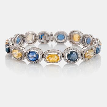 949. An 18K white gold bracelet set with faceted blue and yellow sapphires with a total weight of 25.80 cts.