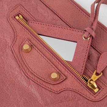 Balenciaga, a pink leather clutch.