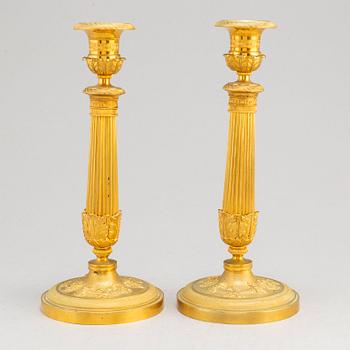A pair of first half of the 19th century Empire candel sticks, gilded bronze, first half of the 19th century.