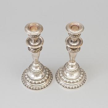 A pair of silver candle sticks, dated 1903.
