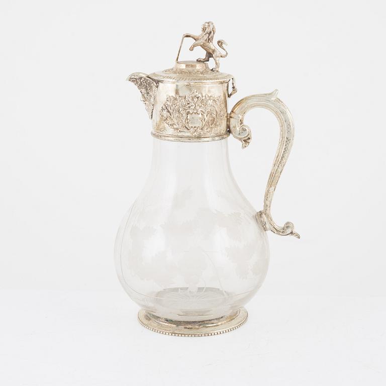 A glass and silver plated jug, around the year 1900.