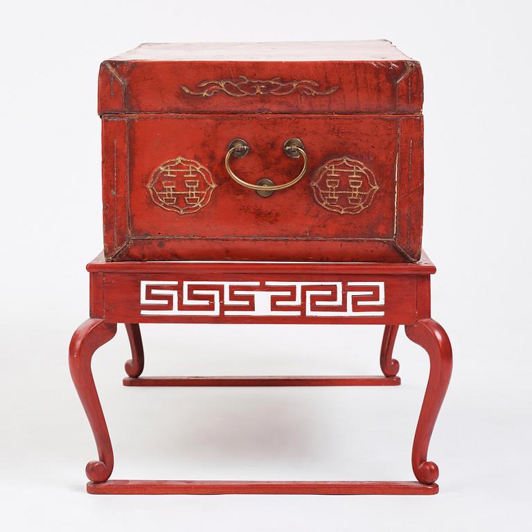 A red lacquered chest on a later stand, late Qing dynasty, 19th Century.