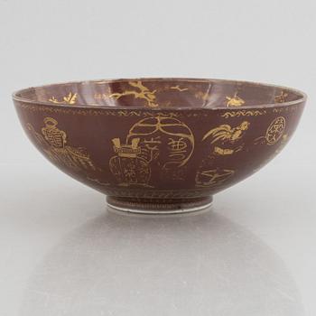 A brown glazed bowl with gilded decoration of animals and antiques, Qing dynasty, 19th century.