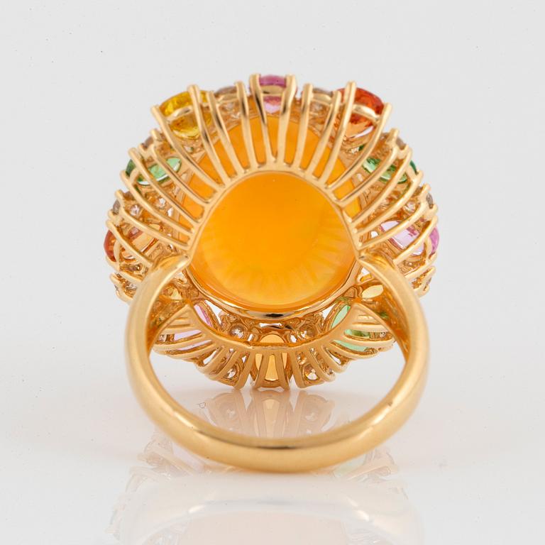 An 18K gold ring set with an opal, round brilliant-cut diamonds.