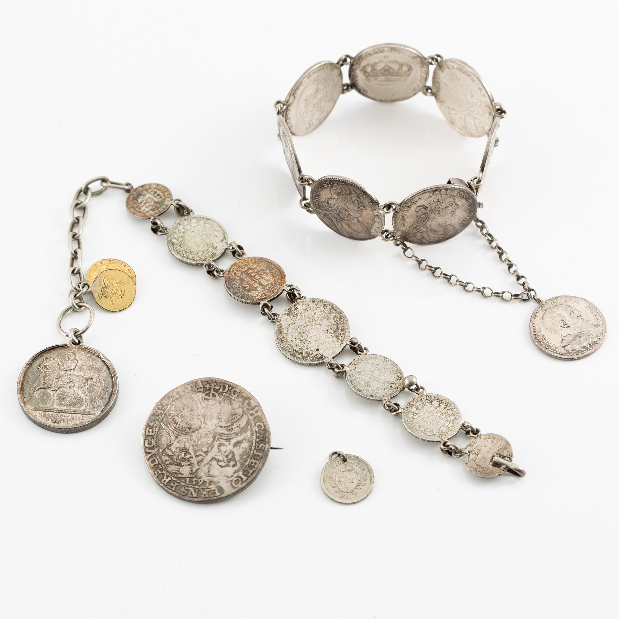 Two bracelets, a brooch, and a pendant with coins.