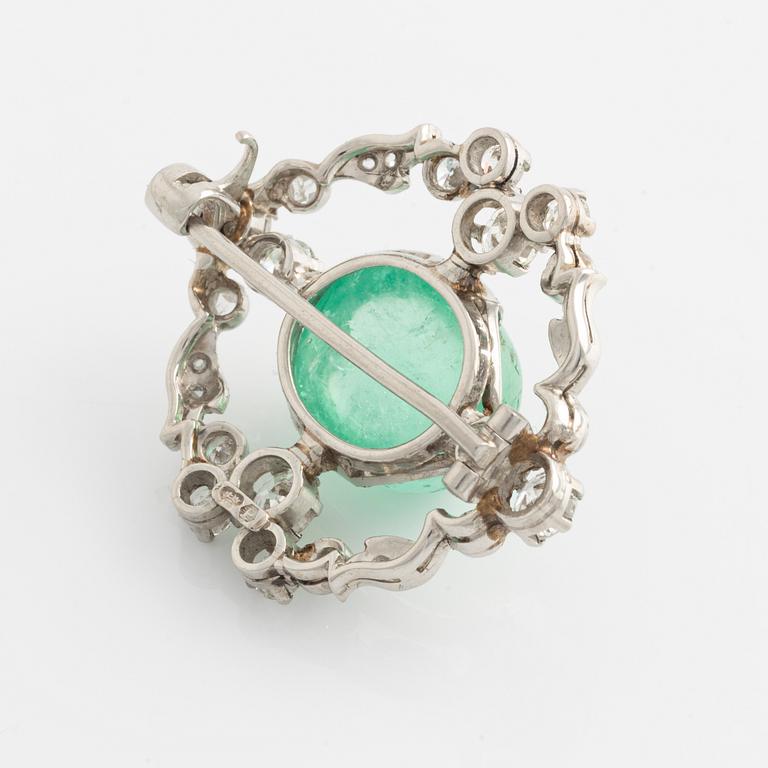 A platinum brooch with a cabochon-cut emerald.