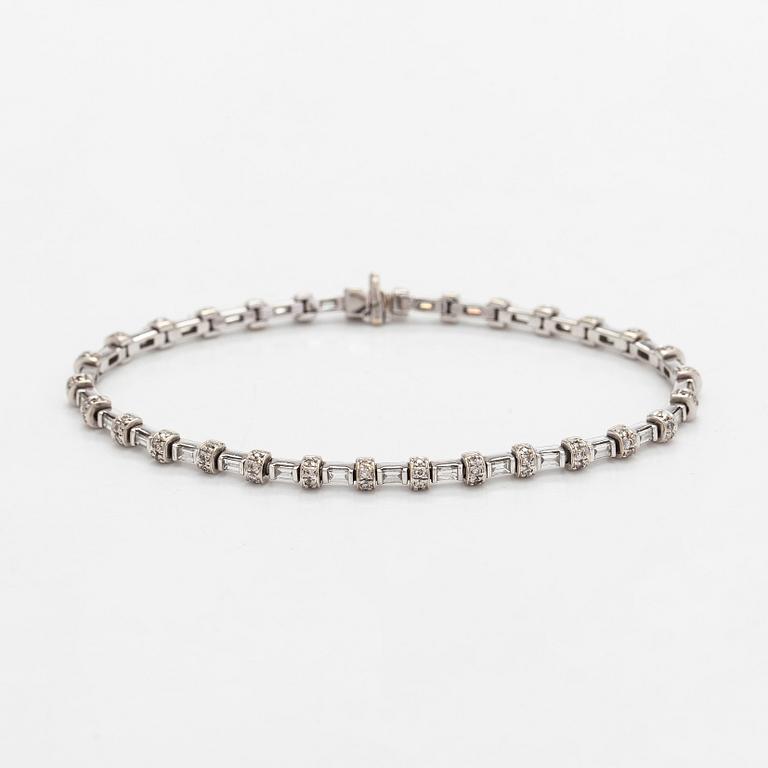 An 18K white gold bracelet set with baguette and brilliant-cut diamonds.