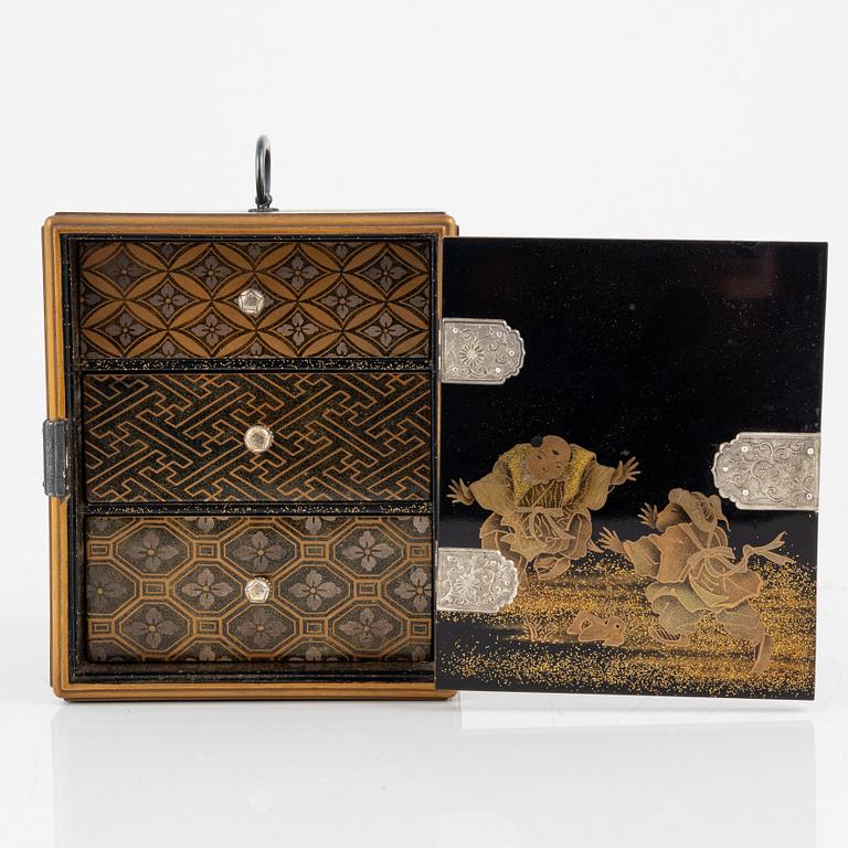 A Japanese lacquer cabinet with tree drawers behind the door, early 20th Century.