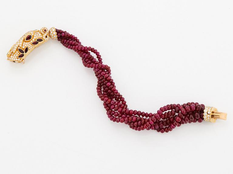 A Cartier chimera head bracelet in 18K gold set with round brilliant-cut diamonds and faceted rubies.