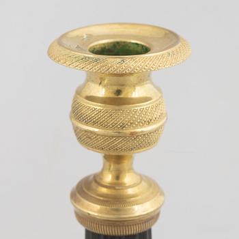 A pair of Empire gilt and patinated brass candlesticks, early 19th century.