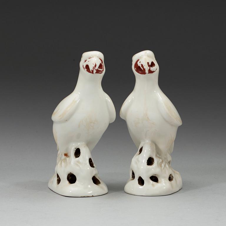 A pair of white and red glazed figures of parrots, late Qing dynasty.