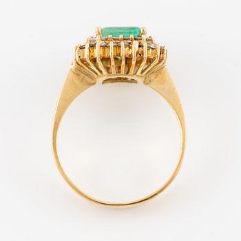 Ring in 18K gold set with a faceted emerald and round brilliant-cut diamonds.