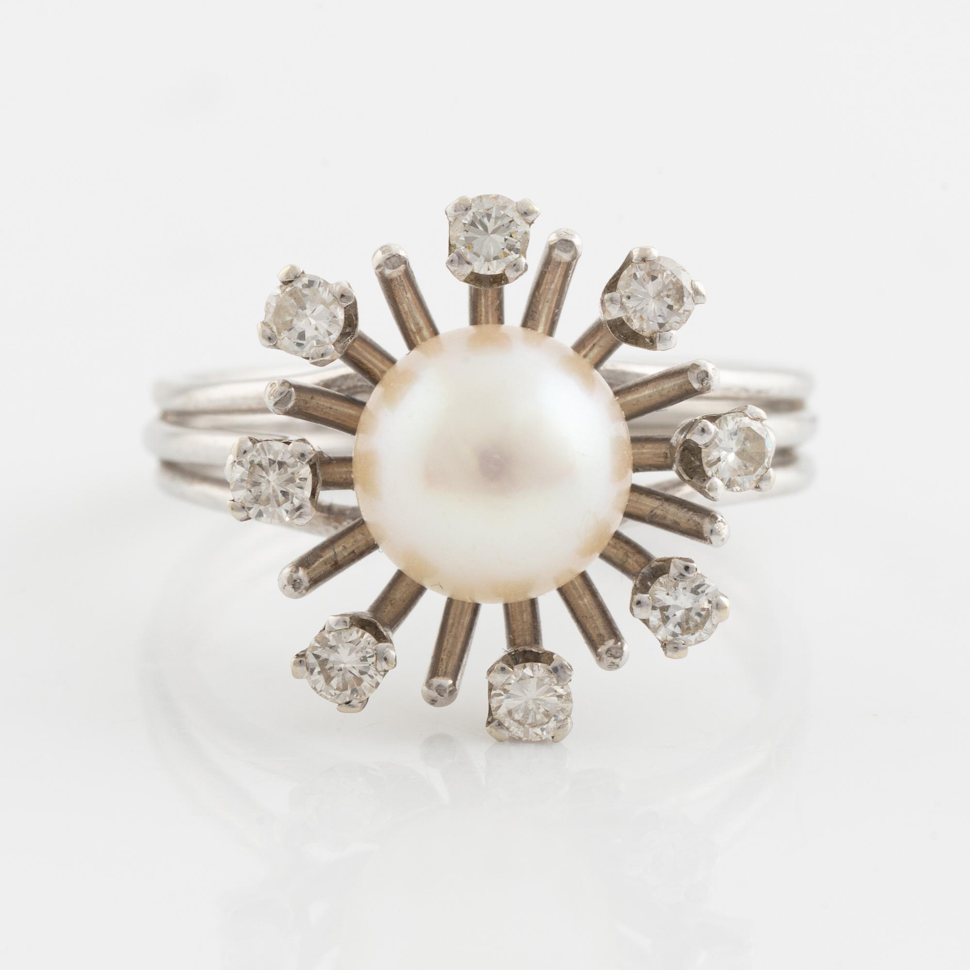 An 18K gold ring set with a cultured pearl and round brilliant-cut diamonds.