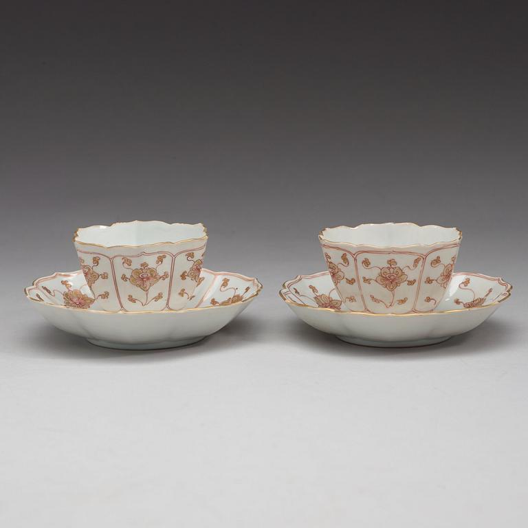 A pair of 'rouge de fer and gold' cups with stands, Qing dynasty, Qianlong (1736-95).