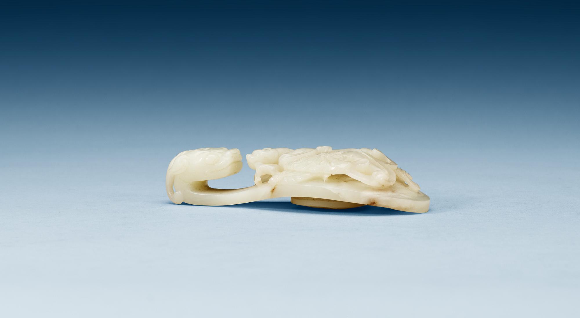 A pale green nephrite garment hook, Qing dynasty.