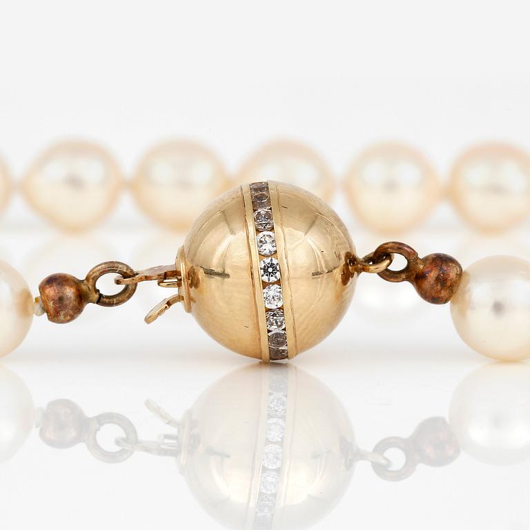 COLLIER, med odlade pärlor och klotformat lås i 18K guld med vita pastestenar.