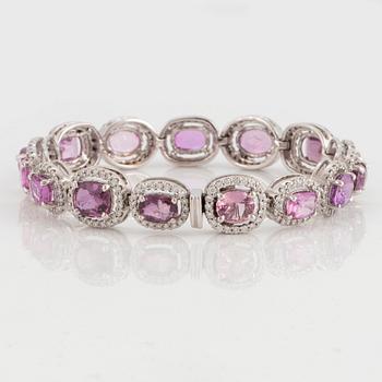 An 18K white gold bracelet set with faceted pink sapphires and round brilliant-cut diamonds.