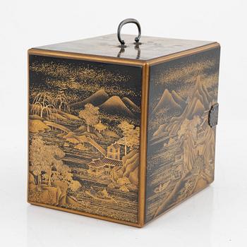 A Japanese lacquer cabinet with tree drawers behind the door, early 20th Century.