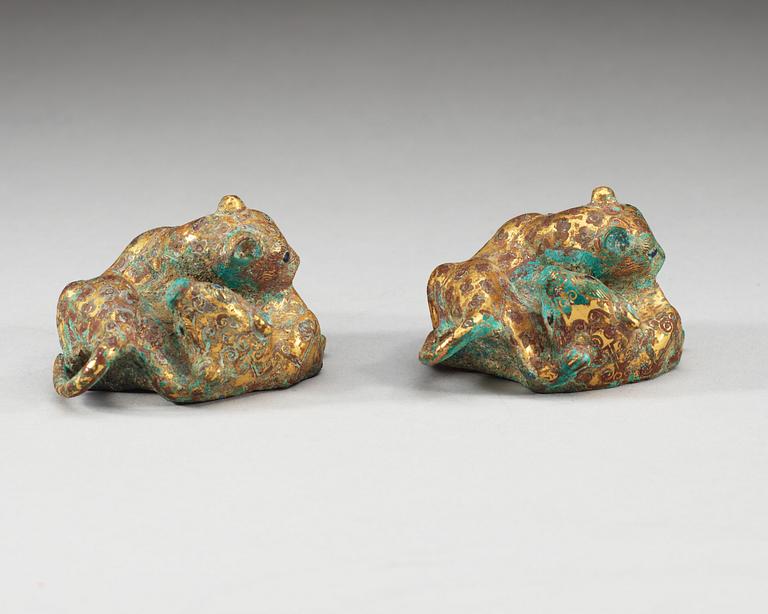 A pair of gilt bronze archaistic weights.