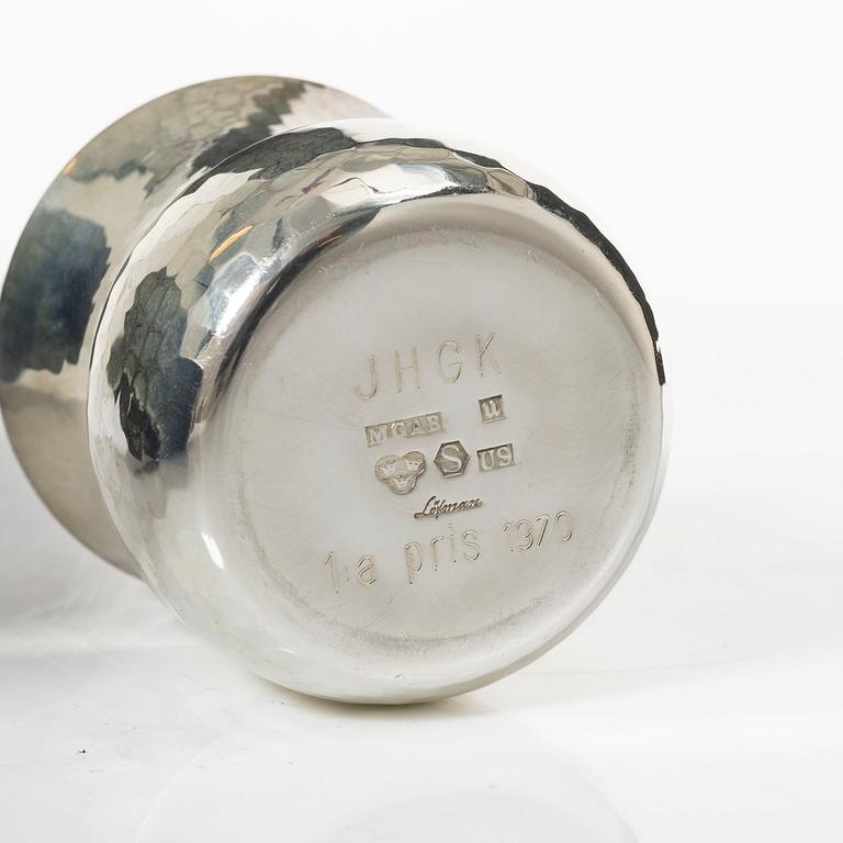 A pair of beakers, two napkin rings, and 17 pieces of cutlery, silver.