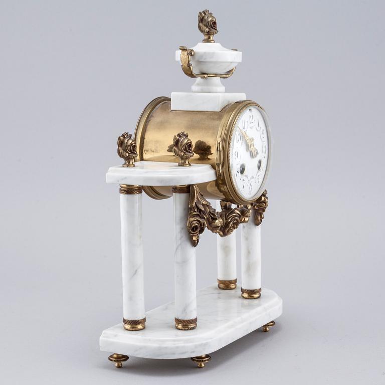 A French mantlepiece clock and a pair of candelabras, first half of the 20th century.