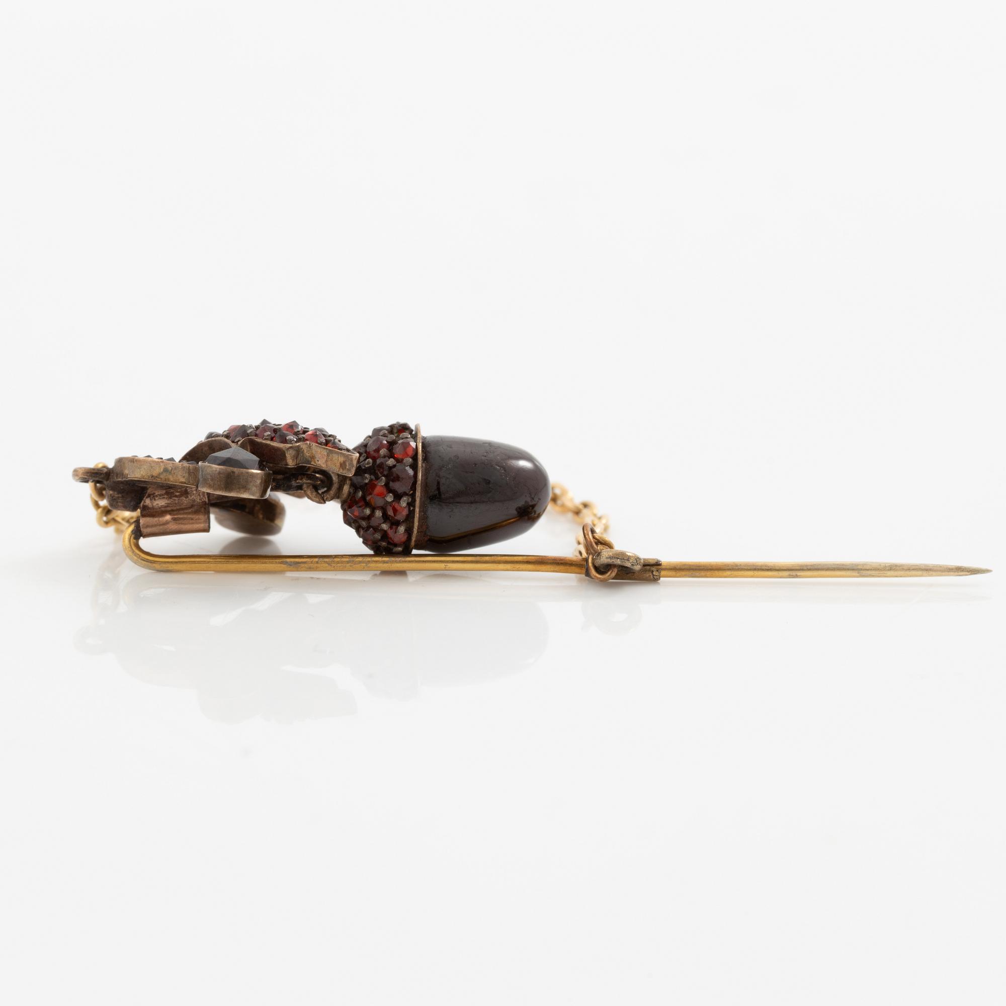 A gold brooch pin set with garnets in the form of acorns, circa 1900.