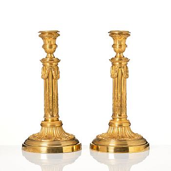 A pair of Louis XVI candlesticks in the manner of Jean Louis Prieurs.