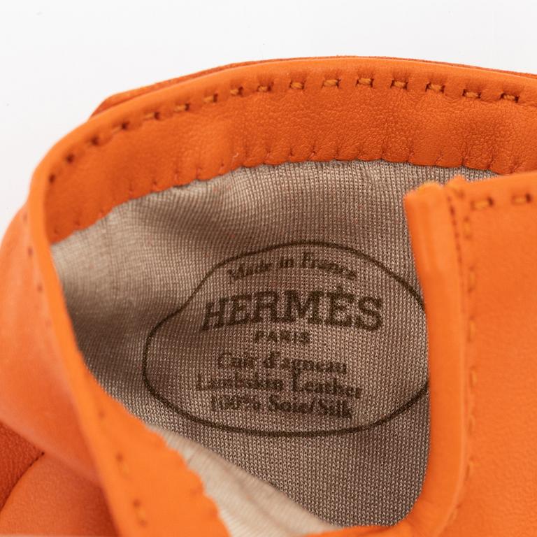 Hermès, a pair of orange kidskin and lambskin gloves, french size 8.