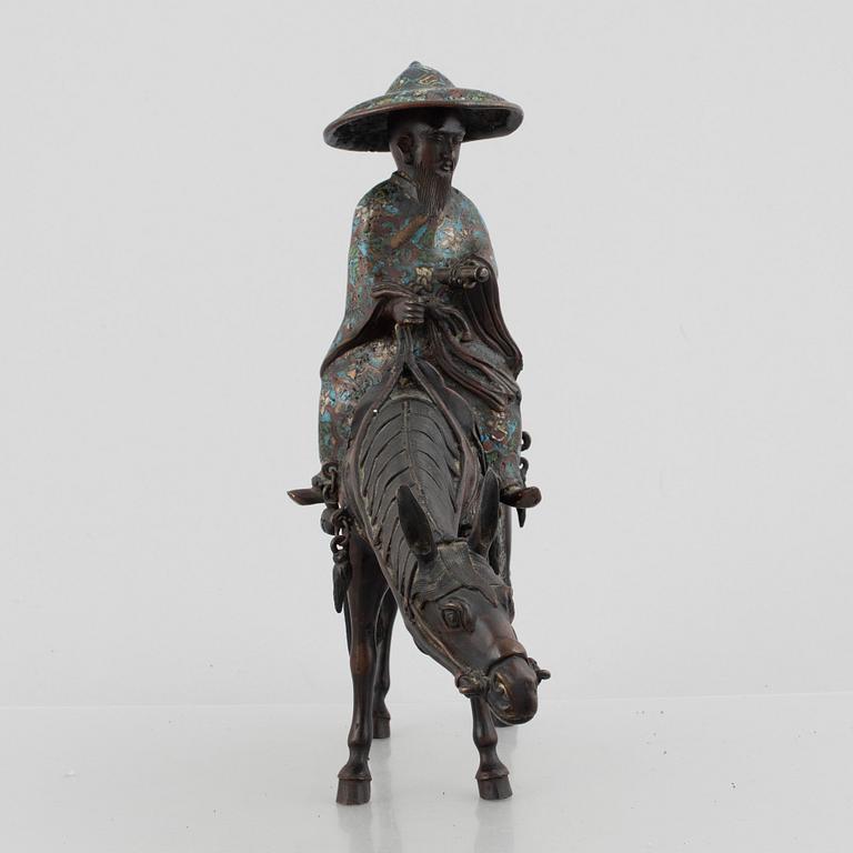 A Chinese bronze and cloissoné figurine on a mule, late Qing/early 20th century.