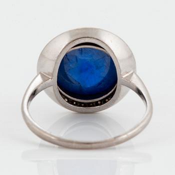 An A Tillander ring in 18K white gold set with a cabochon-cut sapphire and eight-cut diamonds.