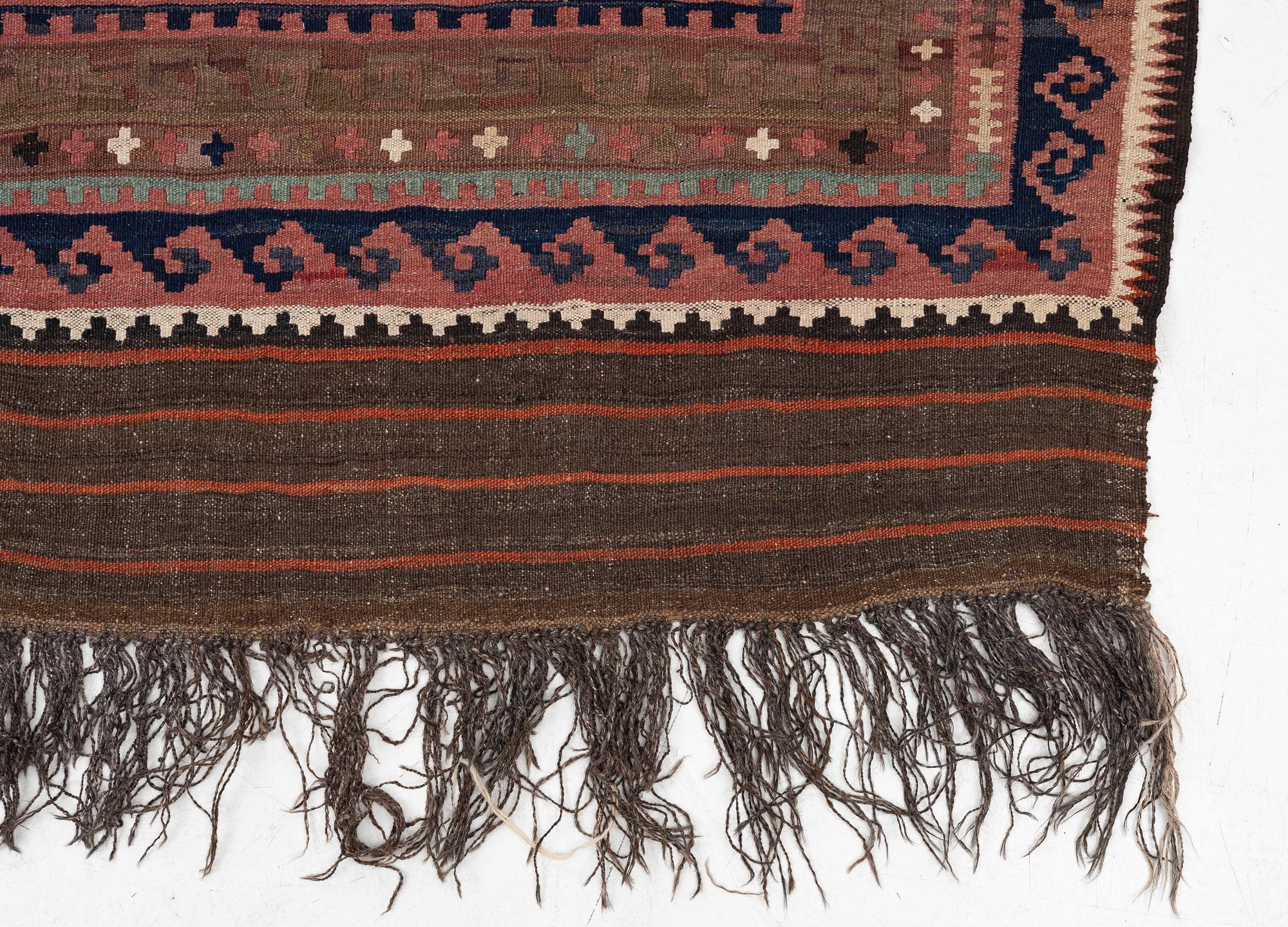 A semi-antique kilim carpet, a. 385 x 251 cm.