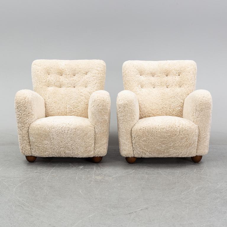 A pair of 1940's lounge chair with later sheepskin upholstery.