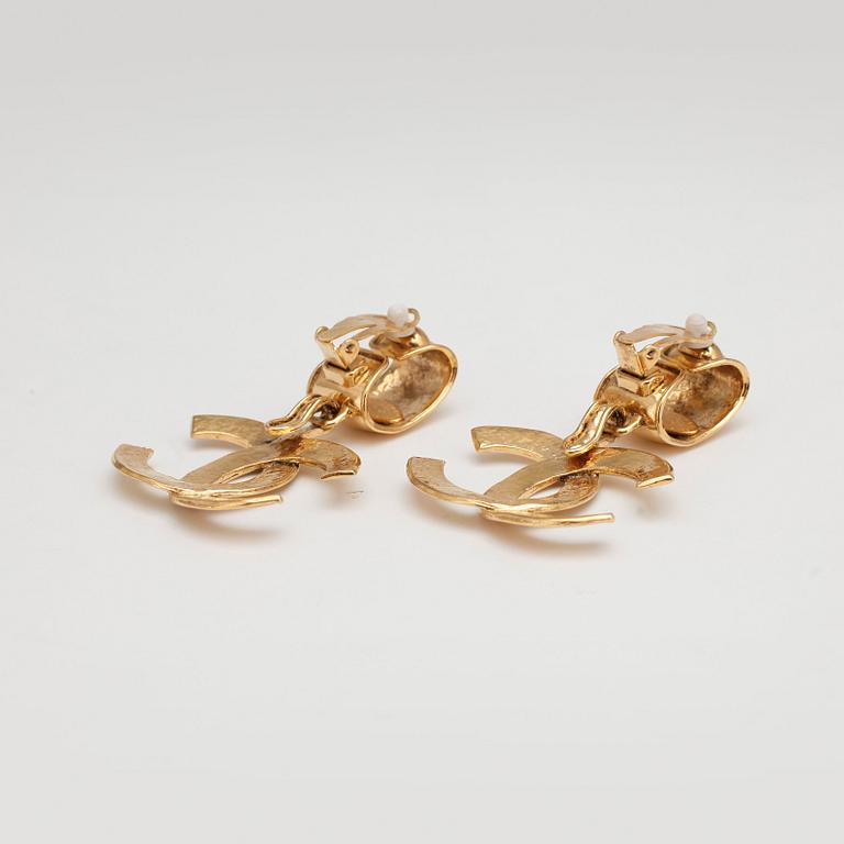 CHANEL, a pair of gold colored logo earclips.