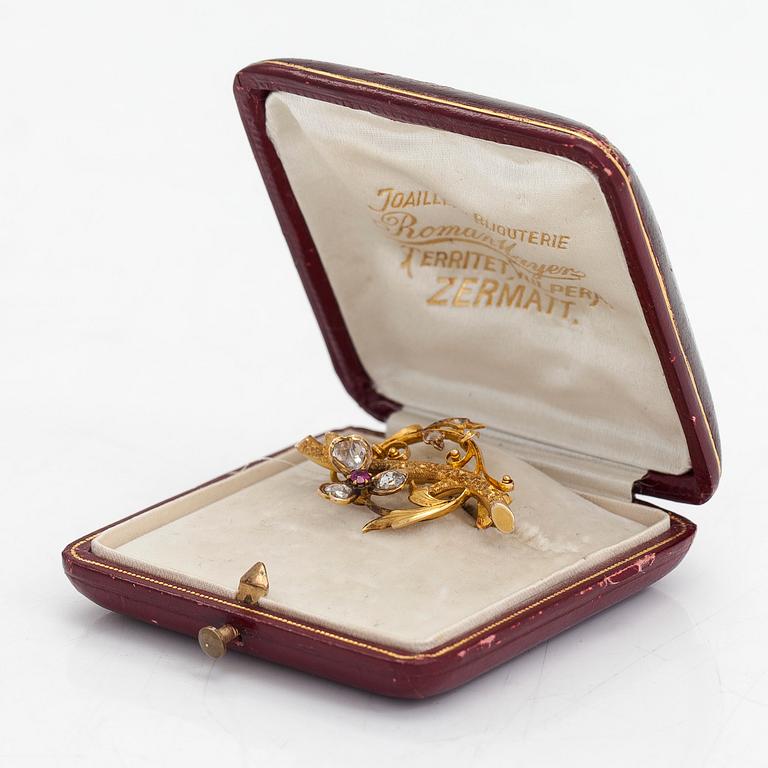 A 14K gold brooch set with rose-cut diamonds and a ruby.