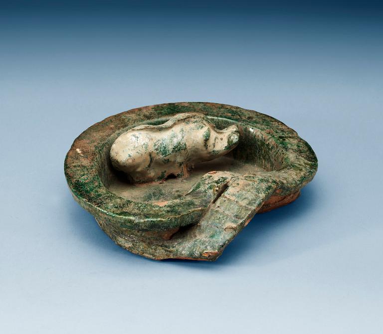 A green glazed heart shaped pigsty with pig, Han dynasty (206 BC- 220 AD).