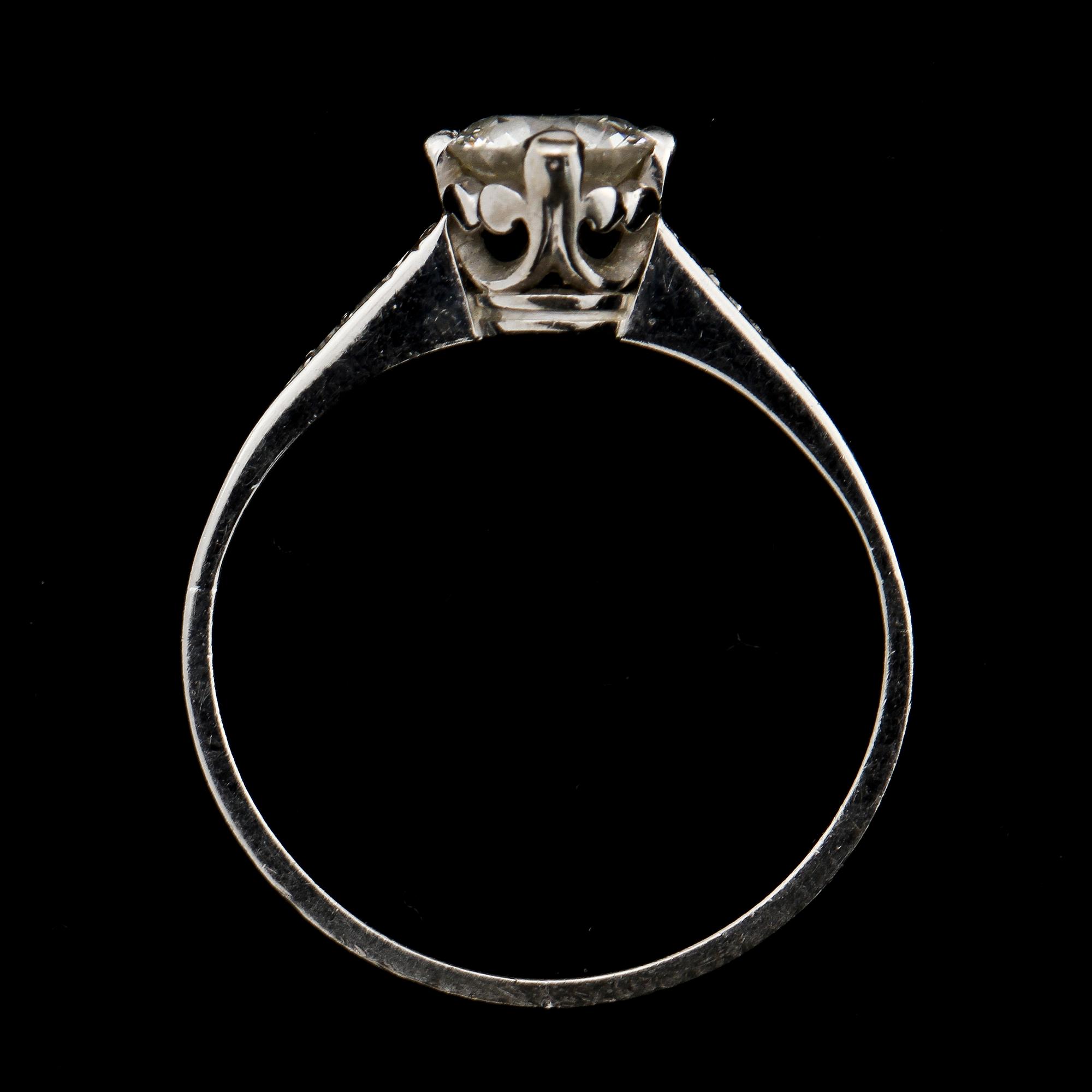 RING, 18k vitguld med briljantslipad diamant ca 0.6 ct samt 6 små åttkantslipade diamanter. Vikt 2 g.