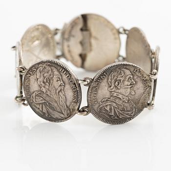 Two bracelets, a brooch, and a pendant with coins.