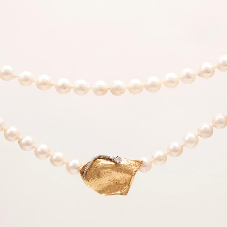 A necklace of cultured pearls, lock in 18K white and red gold set with a round brilliant cut diamond by Ole Lynggaard.