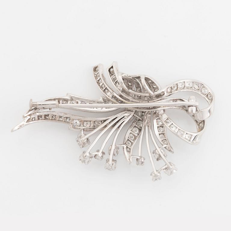 An 18K white gold brooch set with round brilliant-cut diamonds.