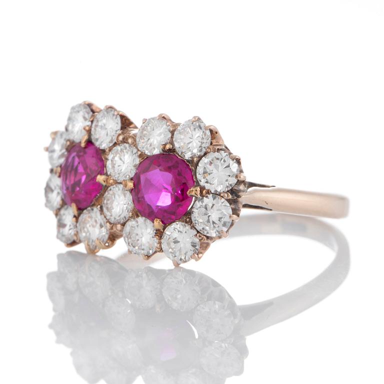 A 14K gold ring set with two faceted rubies ca 0.85 cts and round brilliant-cut diamonds.