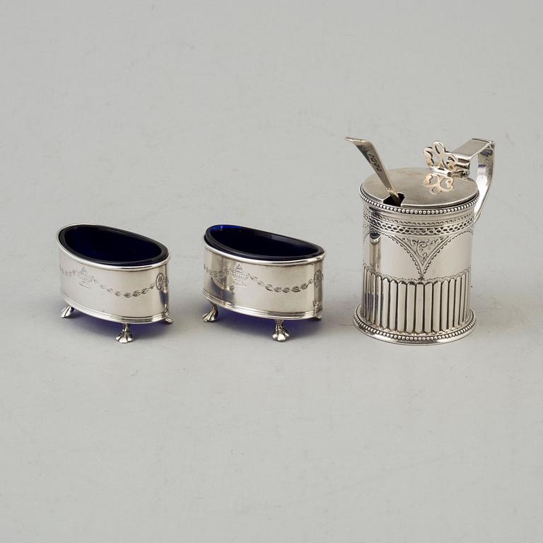 A silver mustard can and a pair of salt cellars. british. Dated 1879 resp. 1911.