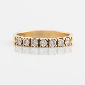 An 18K gold ring set with round briliiant-cut diamonds.
